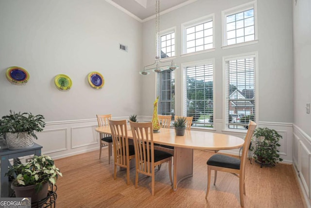 1511 Rocky Knoll Ln, Dacula, GA 30019 - dining space featuring a decorative wall, healthy amount of natural light, ornamental molding, a wainscoted wall, and light wood finished floors