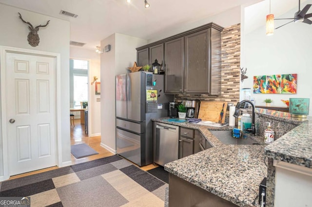 1511 Rocky Knoll Ln, Dacula, GA 30019 - kitchen with appliances with stainless steel finishes, decorative backsplash, dark brown cabinetry, and light stone counters