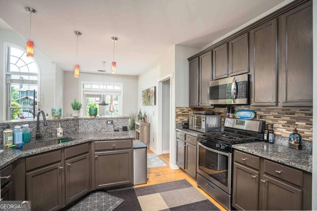 1511 Rocky Knoll Ln, Dacula, GA 30019 - kitchen with appliances with stainless steel finishes, decorative backsplash, dark brown cabinetry, and stone counters