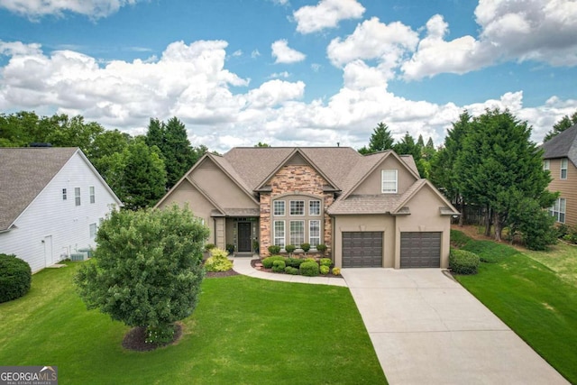 1511 Rocky Knoll Ln, Dacula, GA 30019 - view of front of home with stone siding, stucco siding, concrete driveway, and a front lawn