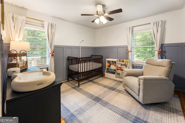 2163 Medfield Trl NE, Chamblee, GA 30345 - bedroom with wainscoting, multiple windows, a decorative wall, a crib, and ceiling fan