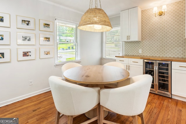 2163 Medfield Trl NE, Chamblee, GA 30345 - dining area with wine cooler, ornamental molding, light wood-type flooring, wallpapered walls, and a dry bar