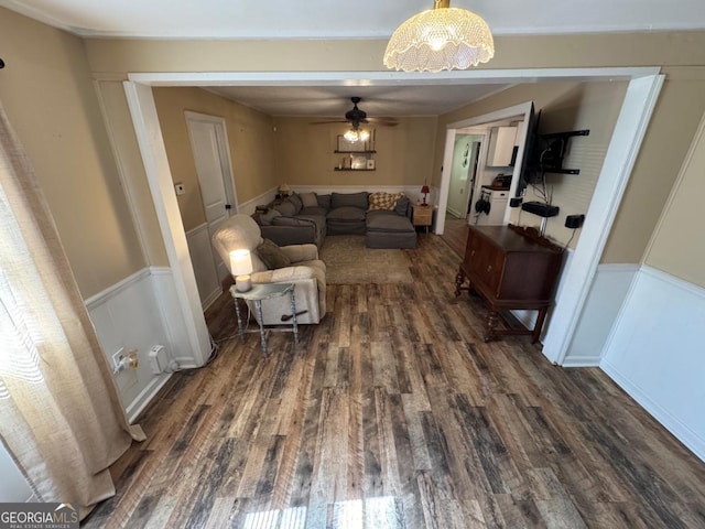 56 Harry Pauls Rd, Danielsville, GA 30633 - living room featuring dark wood finished floors, ceiling fan, a wainscoted wall, a chandelier, and a decorative wall