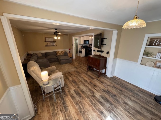 56 Harry Pauls Rd, Danielsville, GA 30633 - living area featuring dark wood-type flooring, a wainscoted wall, ceiling fan, a decorative wall, and built in features