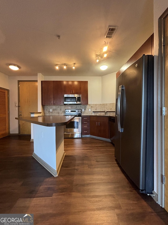 898 Oak St SW Unit 1215, Atlanta, GA 30310 - kitchen featuring appliances with stainless steel finishes, dark countertops, tasteful backsplash, and dark wood finished floors