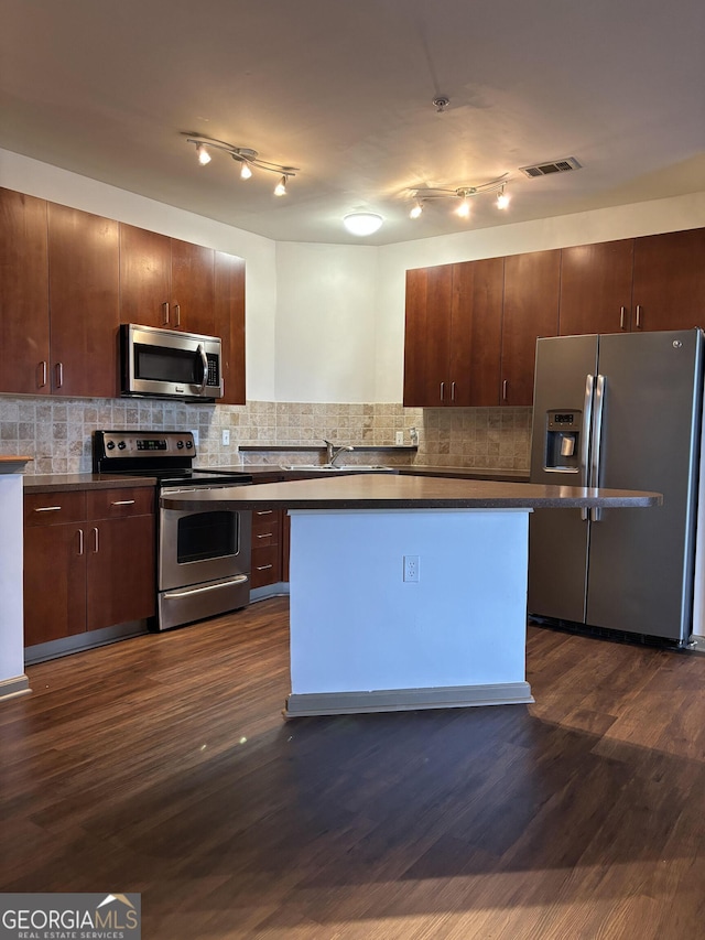 898 Oak St SW Unit 1215, Atlanta, GA 30310 - kitchen with appliances with stainless steel finishes, dark countertops, dark wood-style floors, and backsplash