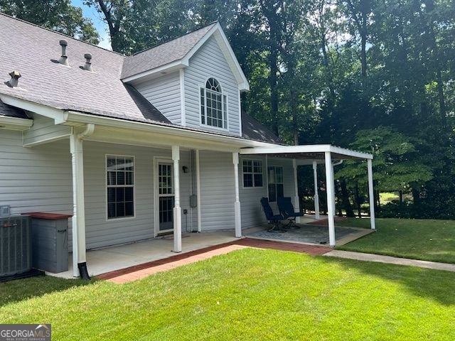 149 Crown Oaks Dr, Stockbridge, GA 30281 - back of property with a lawn, roof with shingles, and a patio area