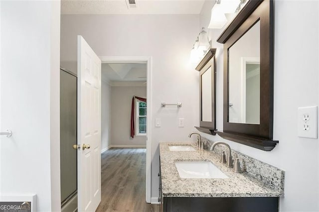 13440 Avensong Xing, Alpharetta, GA 30004 - full bathroom with double vanity, wood finished floors, and a shower with door