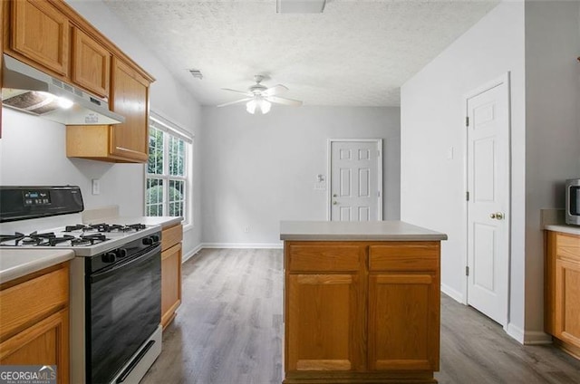 13440 Avensong Xing, Alpharetta, GA 30004 - kitchen featuring gas range oven, under cabinet range hood, wood finished floors, ceiling fan, and a textured ceiling