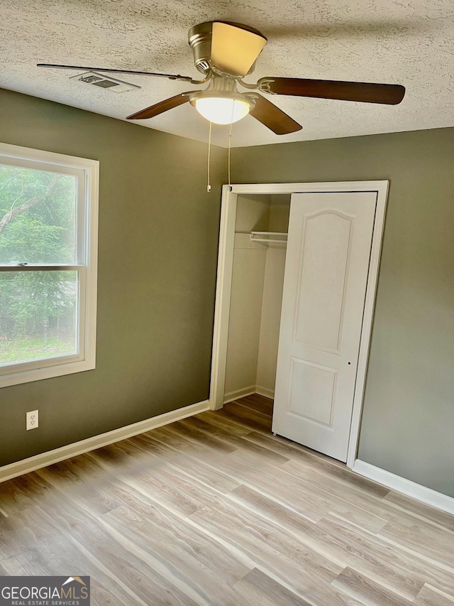 935 Mccall Rd, Macon, GA 31217 - unfurnished bedroom with light wood finished floors, a closet, ceiling fan, and a textured ceiling