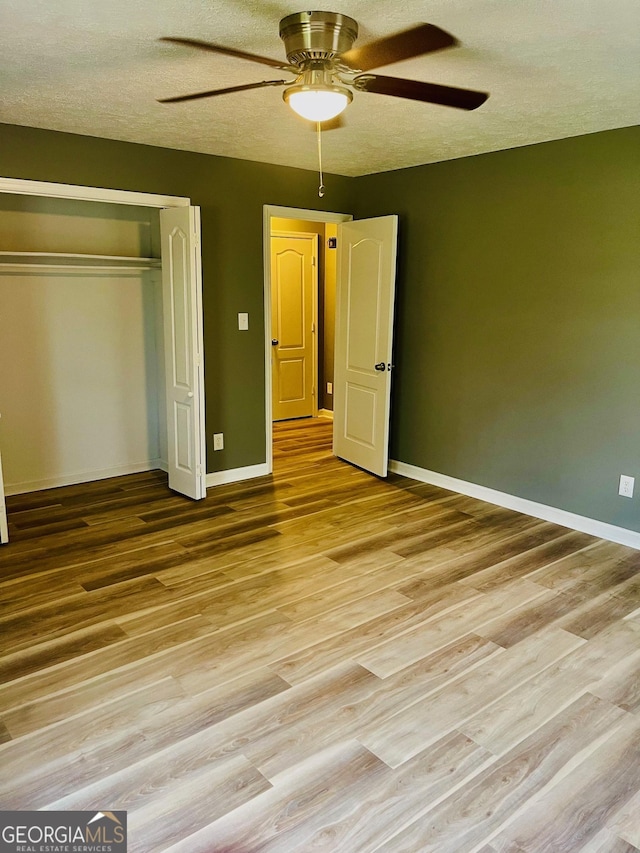 935 Mccall Rd, Macon, GA 31217 - unfurnished bedroom featuring wood finished floors, a closet, a ceiling fan, and a textured ceiling