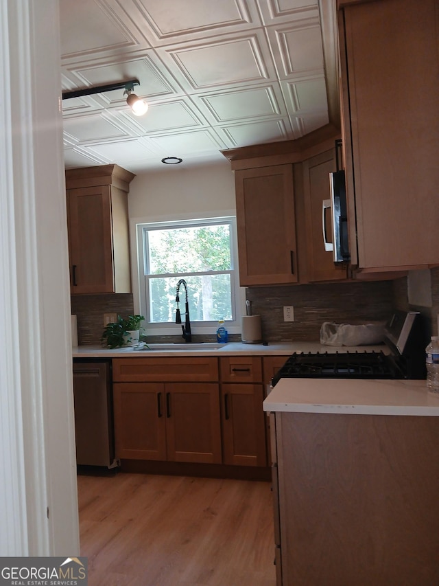 6985 Butner Rd, South Fulton, GA 30349 - kitchen with stainless steel appliances, backsplash, an ornate ceiling, light wood-style floors, and light countertops