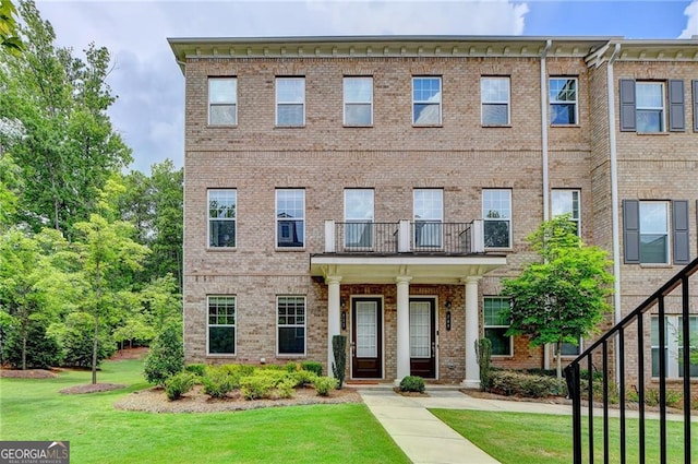 711 Topsail Ln, Alpharetta, GA 30005 - view of front of house with a front lawn, brick siding, and a balcony
