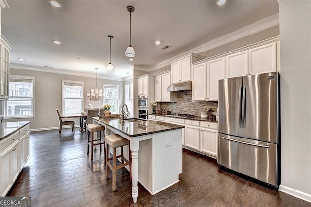 711 Topsail Ln, Alpharetta, GA 30005 - kitchen featuring appliances with stainless steel finishes, under cabinet range hood, white cabinetry, crown molding, and backsplash