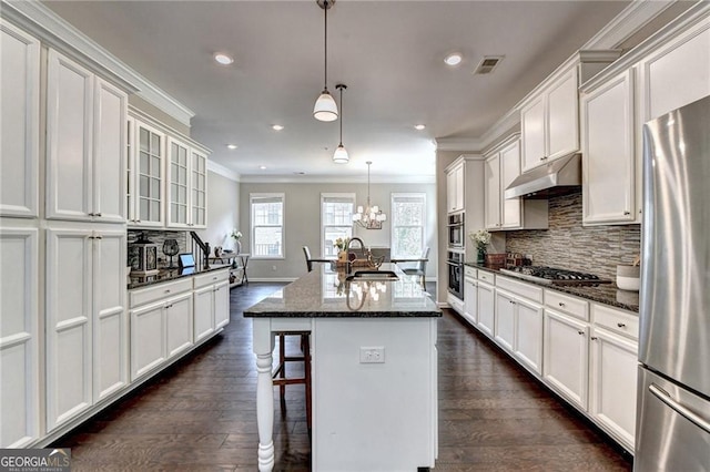 711 Topsail Ln, Alpharetta, GA 30005 - kitchen featuring appliances with stainless steel finishes, under cabinet range hood, ornamental molding, dark wood-style flooring, and tasteful backsplash