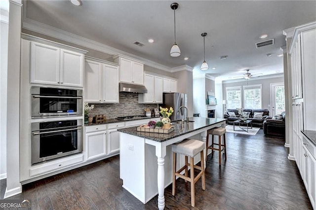 711 Topsail Ln, Alpharetta, GA 30005 - kitchen with open floor plan, stainless steel appliances, a breakfast bar area, white cabinets, and recessed lighting