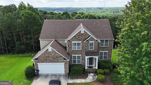 773 Van Briggle Path, Sugar Hill, GA 30518 - traditional-style house with brick siding, a front lawn, an attached garage, a view of trees, and driveway