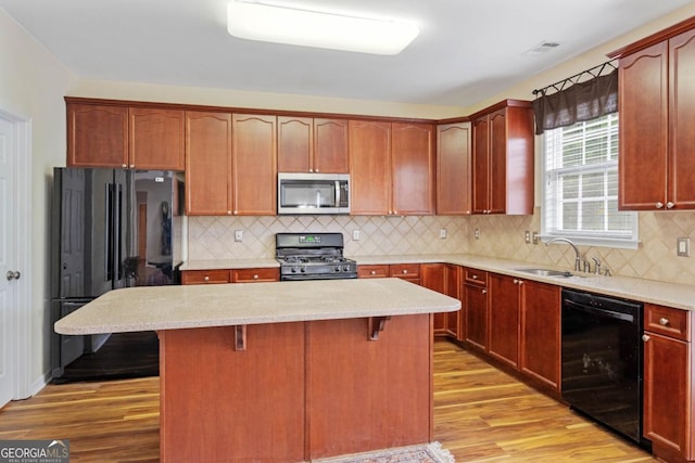 773 Van Briggle Path, Sugar Hill, GA 30518 - kitchen with black appliances, light wood-type flooring, a breakfast bar, backsplash, and a kitchen island