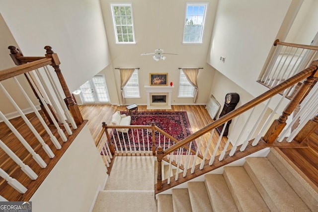 773 Van Briggle Path, Sugar Hill, GA 30518 - stairs with a high ceiling, wood finished floors, ceiling fan, and a fireplace