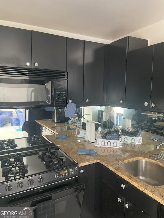 620 NE Peachtree St Unit 901, Atlanta, GA 30308 - kitchen with black appliances, dark cabinets, and light stone counters