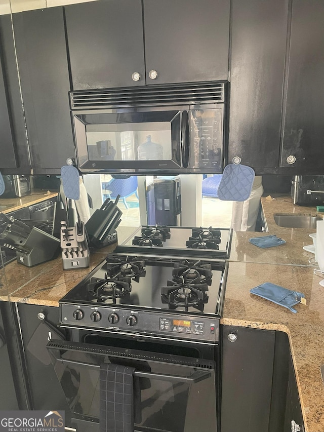 620 NE Peachtree St Unit 901, Atlanta, GA 30308 - kitchen with black appliances and light stone counters