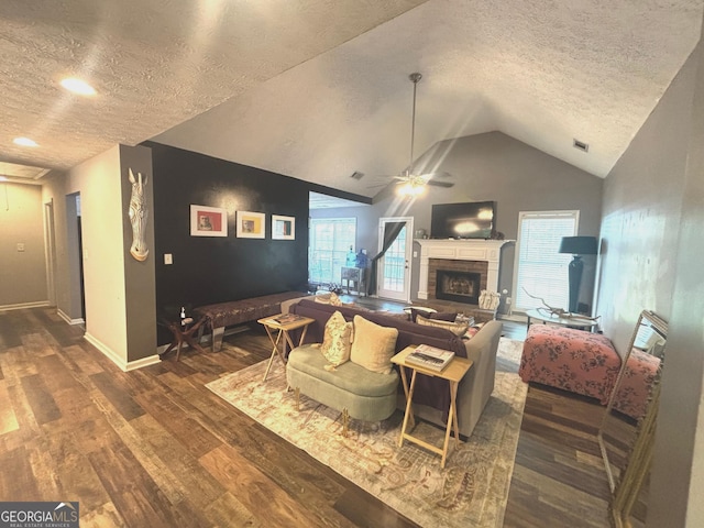 214 Sugar Hill Ct, Jackson, GA 30233 - living room featuring a ceiling fan, wood finished floors, a fireplace with raised hearth, a textured ceiling, and vaulted ceiling