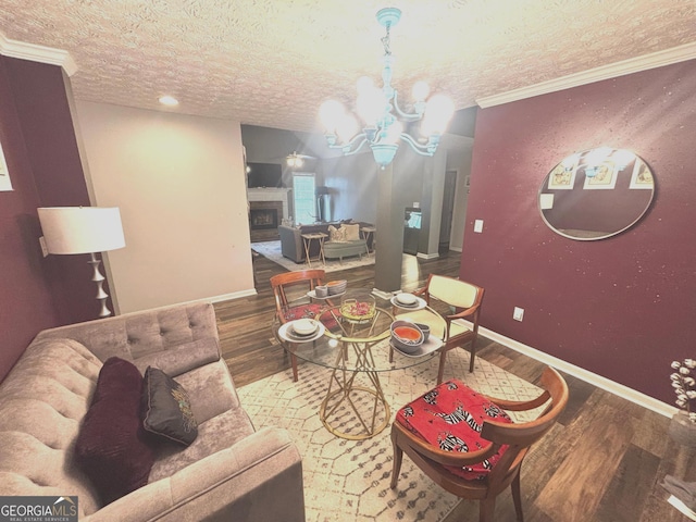 214 Sugar Hill Ct, Jackson, GA 30233 - living area with wood finished floors, a chandelier, a textured ceiling, a fireplace, and ornamental molding
