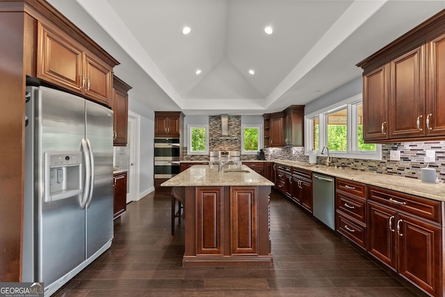 1572 Azalea Dr, Lawrenceville, GA 30043 - kitchen with stainless steel appliances, tasteful backsplash, wall chimney exhaust hood, light stone counters, and a kitchen island with sink