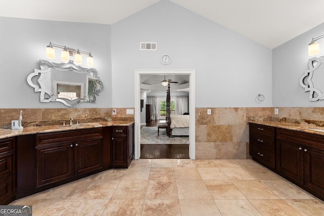 1572 Azalea Dr, Lawrenceville, GA 30043 - ensuite bathroom featuring two vanities, ceiling fan, high vaulted ceiling, tile patterned floors, and tile walls