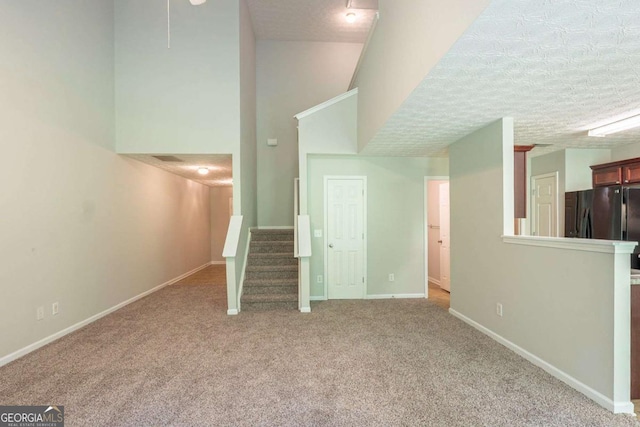 513 Shadow Valley Ct, Lithonia, GA 30058 - unfurnished living room featuring carpet flooring, stairs, and a towering ceiling