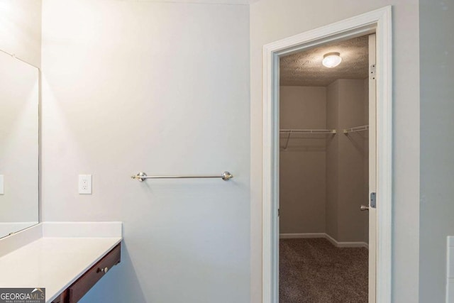 513 Shadow Valley Ct, Lithonia, GA 30058 - bathroom featuring vanity, a walk in closet, and a textured ceiling