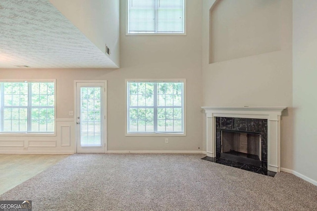 513 Shadow Valley Ct, Lithonia, GA 30058 - unfurnished living room with carpet floors, a premium fireplace, a high ceiling, plenty of natural light, and a wainscoted wall