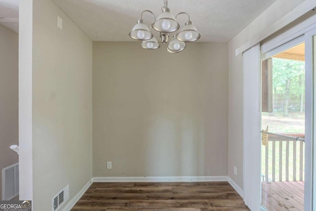 5207 Shawn Ln, Stone Mountain, GA 30088 - unfurnished dining area with a chandelier, dark wood finished floors, and a textured ceiling