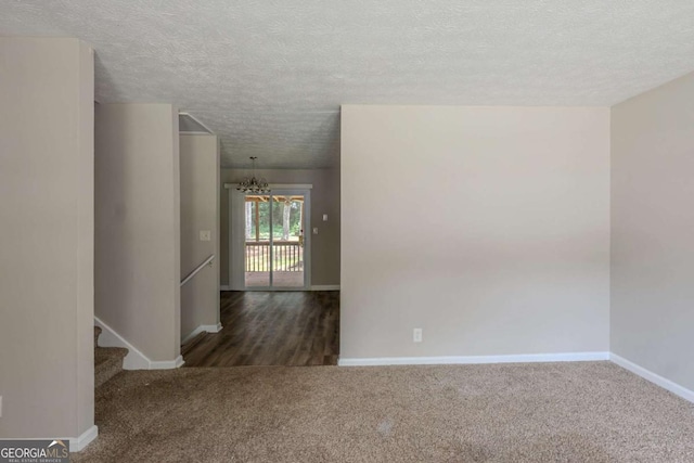 5207 Shawn Ln, Stone Mountain, GA 30088 - spare room featuring a textured ceiling, carpet flooring, a chandelier, and stairway