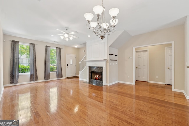 13495 Spring View Dr, Alpharetta, GA 30004 - unfurnished living room with light wood-style flooring, a ceiling fan, a chandelier, and a high end fireplace