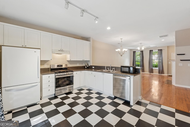 13495 Spring View Dr, Alpharetta, GA 30004 - kitchen with stainless steel appliances, under cabinet range hood, light floors, dark countertops, and a chandelier