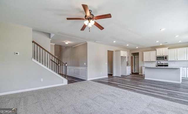 1172 Faulkner Way, Jonesboro, GA 30238 - unfurnished living room featuring ceiling fan, dark carpet, stairs, recessed lighting, and dark wood-style flooring