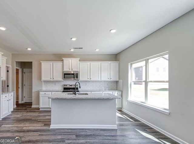1172 Faulkner Way, Jonesboro, GA 30238 - kitchen with stainless steel appliances, decorative backsplash, white cabinetry, a kitchen island with sink, and recessed lighting