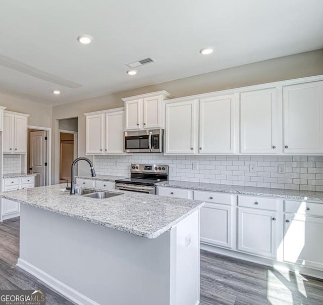 1172 Faulkner Way, Jonesboro, GA 30238 - kitchen featuring appliances with stainless steel finishes, wood finished floors, decorative backsplash, white cabinets, and recessed lighting
