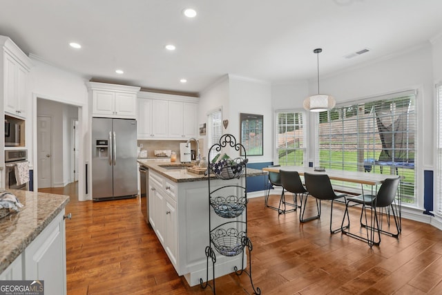 2009 Mclain Rd NW, Acworth, GA 30101 - kitchen with appliances with stainless steel finishes, ornamental molding, wood finished floors, white cabinetry, and healthy amount of natural light