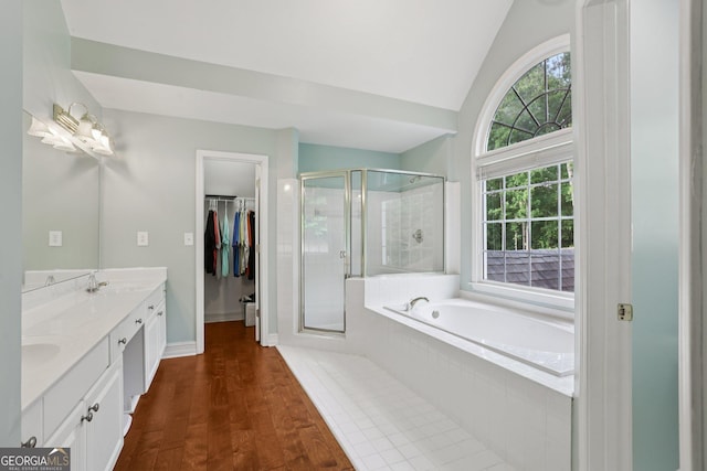 2009 Mclain Rd NW, Acworth, GA 30101 - full bathroom with double vanity, a stall shower, a bath, a walk in closet, and wood finished floors