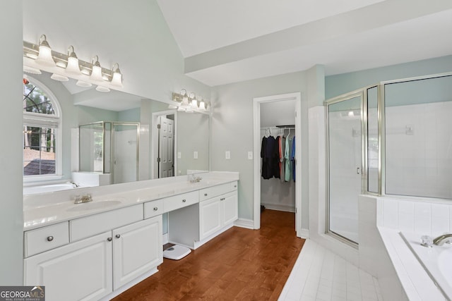 2009 Mclain Rd NW, Acworth, GA 30101 - bathroom featuring vanity, a stall shower, a garden tub, a walk in closet, and wood finished floors