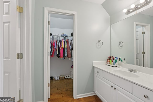 2009 Mclain Rd NW, Acworth, GA 30101 - bathroom with vanity, a walk in closet, and wood finished floors