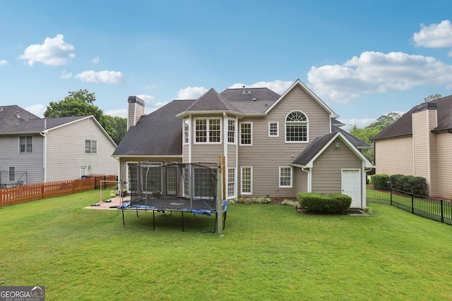 2009 Mclain Rd NW, Acworth, GA 30101 - back of property with a trampoline, a fenced backyard, a chimney, and a shingled roof