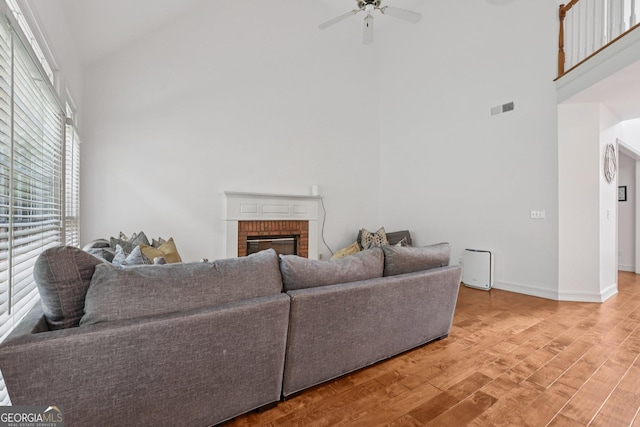 2009 Mclain Rd NW, Acworth, GA 30101 - living room with high vaulted ceiling, light wood-style floors, a brick fireplace, and a ceiling fan