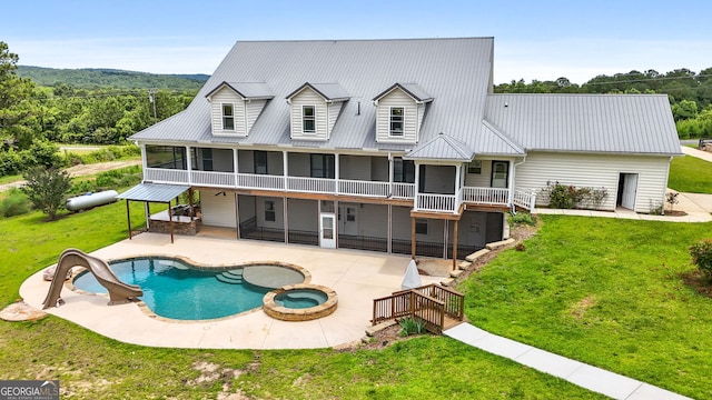 735 Firetower Rd, Thomaston, GA 30286 - back of property featuring a sunroom, a patio, a lawn, a metal roof, and a pool with connected hot tub
