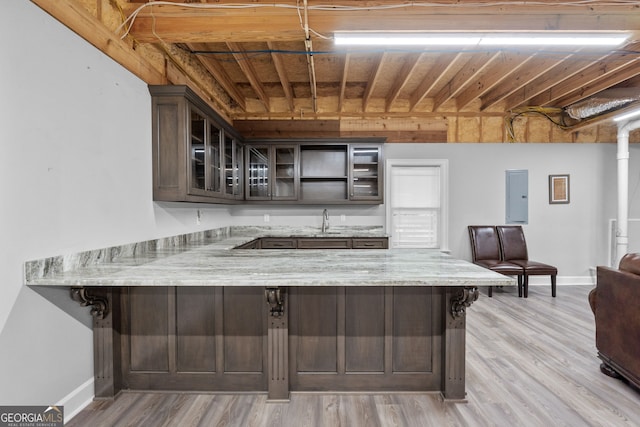 735 Firetower Rd, Thomaston, GA 30286 - kitchen featuring electric panel, a peninsula, glass insert cabinets, and light stone countertops