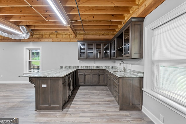 735 Firetower Rd, Thomaston, GA 30286 - kitchen with a peninsula, light stone counters, glass insert cabinets, dark brown cabinets, and beam ceiling