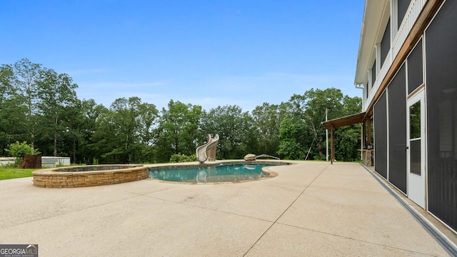 735 Firetower Rd, Thomaston, GA 30286 - view of pool with a water slide, a patio, a pool with connected hot tub, and view of wooded area