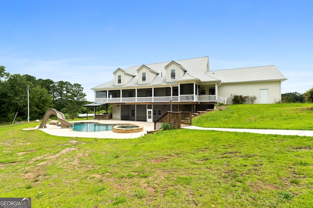 735 Firetower Rd, Thomaston, GA 30286 - back of property with a sunroom, a yard, a pool with connected hot tub, and a metal roof